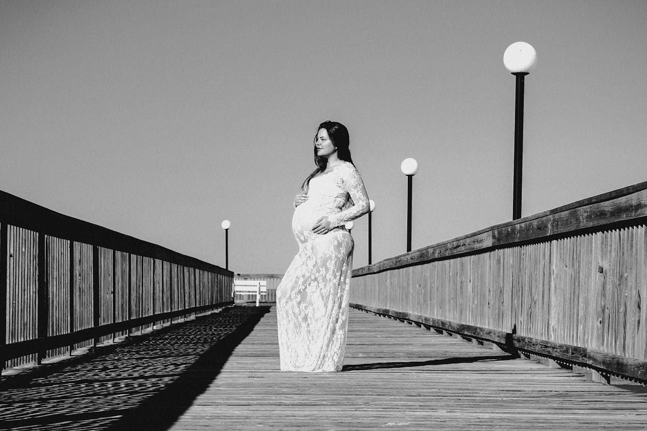 Grayscale Photo of Pregnant Woman Wearing Maxi Dress